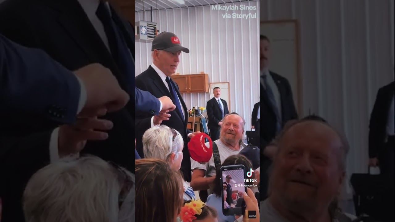 Biden tries on a MAGA Trump hat at event