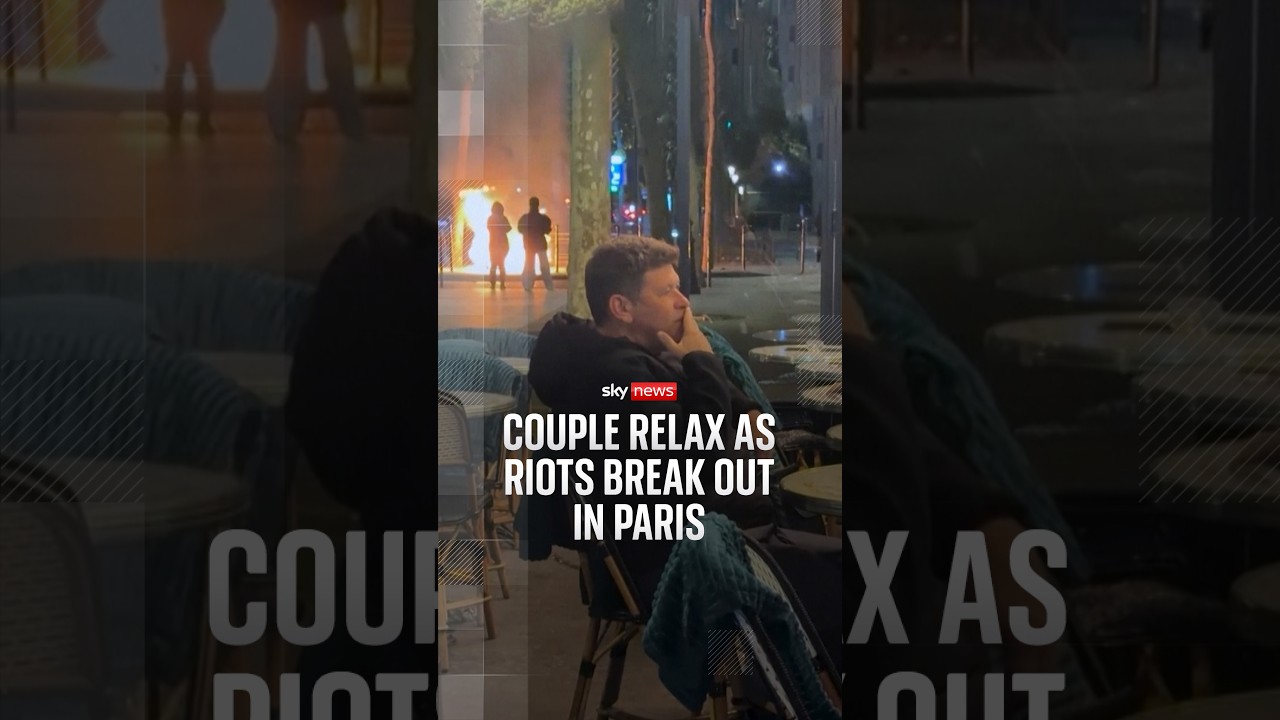 Couple relax as riots break out in Paris